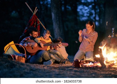 Family Picnic In The Woods With Fire; Spring Or Autumn Camping With Campfire At Night ; Camping, Travel, Tourism, Hike And People Concept. Quality Family Time Together.