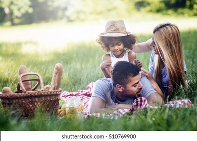 Family picnicking outdoors with their cute daughter