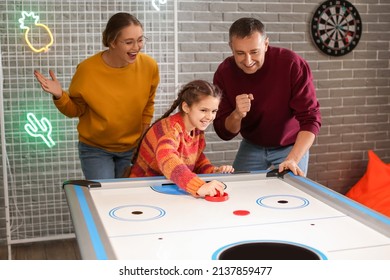 Family Playing Air Hockey Indoors