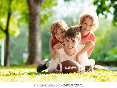 Family playing American football. Kids play rugby in sunny summer park. Father and children throw ball, run and laugh. Healthy outdoor sport activity. - Powered by Shutterstock