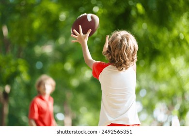 Family playing American football. Kids play rugby in sunny summer park. Father and children throw ball, run and laugh. Healthy outdoor sport activity. - Powered by Shutterstock