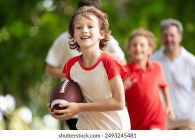 Family playing American football. Kids play rugby in sunny summer park. Father and children throw ball, run and laugh. Healthy outdoor sport activity. - Powered by Shutterstock