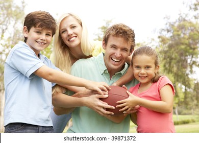 Family Playing American Football Together In Park