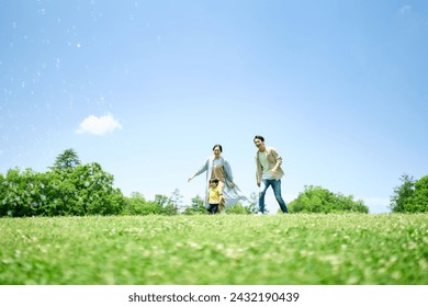 A family playing around on a green hill - Powered by Shutterstock