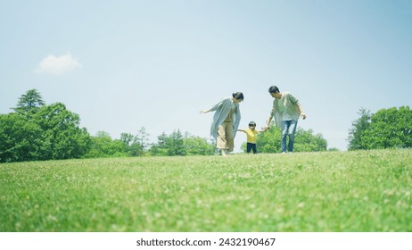 A family playing around on a green hill - Powered by Shutterstock