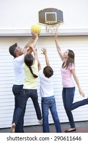 Family Playing Basketball Outside Garage