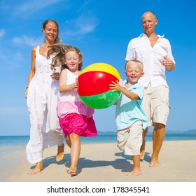 Family Playing With Beach Ball On Beach