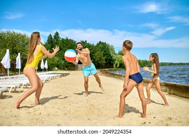 A Family Playing Beach Volleyball And Feeling Happy