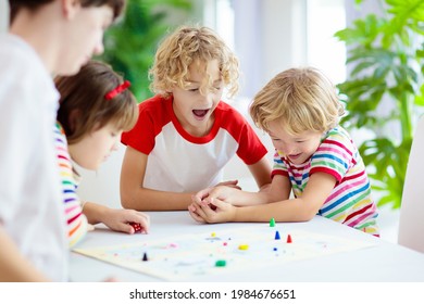 Family Playing Board Game At Home. Kids Play Strategic Game. Little Boy Throwing Dice. Fun Indoor Activity For Summer Vacation. Siblings Bond. Educational Toys. Friends Enjoy Game Night.