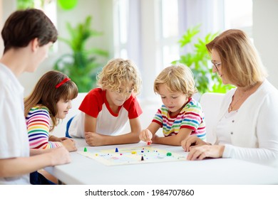 Family Playing Board Game At Home. Kids Play Strategic Game. Little Boy Throwing Dice. Fun Indoor Activity For Summer Vacation. Siblings Bond. Educational Toys. Friends Enjoy Game Night.