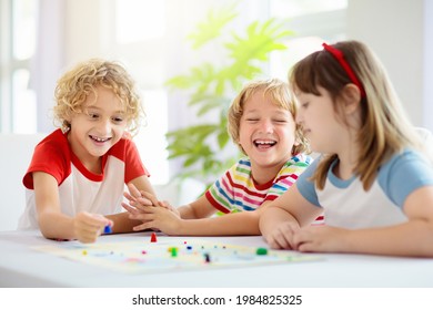 Family Playing Board Game At Home. Kids Play Strategic Game. Little Boy Throwing Dice. Fun Indoor Activity For Summer Vacation. Siblings Bond. Educational Toys. Friends Enjoy Game Night.