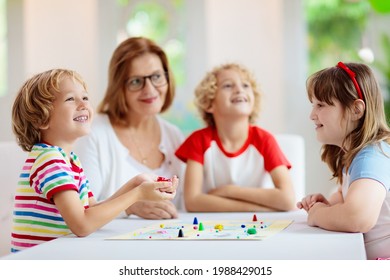 Family Playing Board Game At Home. Kids Play Strategic Game. Little Boy Throwing Dice. Fun Indoor Activity For Summer Vacation. Siblings Bond. Educational Toys. Friends Enjoy Game Night.