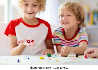 Family Playing Board Game At Home. Kids Play Strategic Game. Little Boy Throwing Dice. Fun Indoor Activity For Summer Vacation. Siblings Bond. Educational Toys. Friends Enjoy Game Night.