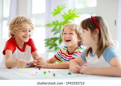 Family Playing Board Game At Home. Kids Play Strategic Game. Little Boy Throwing Dice. Fun Indoor Activity For Summer Vacation. Siblings Bond. Educational Toys. Friends Enjoy Game Night.