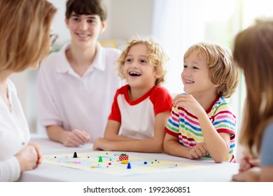 Family Playing Board Game At Home. Kids Play Strategic Game. Little Boy Throwing Dice. Fun Indoor Activity For Summer Vacation. Siblings Bond. Educational Toys. Friends Enjoy Game Night.