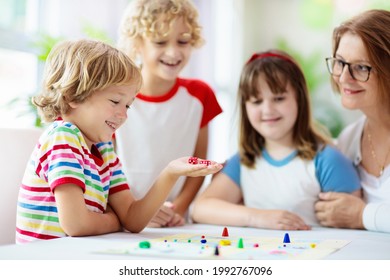 Family Playing Board Game At Home. Kids Play Strategic Game. Little Boy Throwing Dice. Fun Indoor Activity For Summer Vacation. Siblings Bond. Educational Toys. Friends Enjoy Game Night.