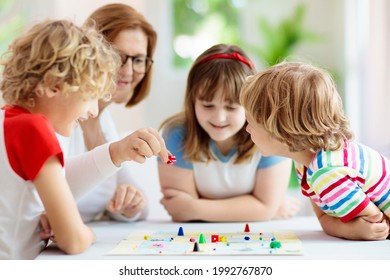 Family Playing Board Game At Home. Kids Play Strategic Game. Little Boy Throwing Dice. Fun Indoor Activity For Summer Vacation. Siblings Bond. Educational Toys. Friends Enjoy Game Night.