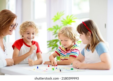 Family Playing Board Game At Home. Kids Play Strategic Game. Little Boy Throwing Dice. Fun Indoor Activity For Summer Vacation. Siblings Bond. Educational Toys. Friends Enjoy Game Night.