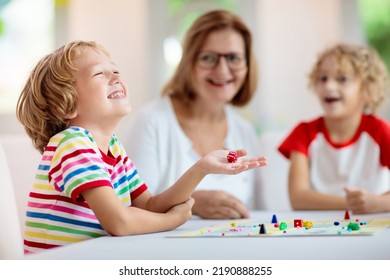 Family Playing Board Game At Home. Kids Play Strategic Game. Little Boy Throwing Dice. Fun Indoor Activity For Summer Vacation. Siblings Bond. Educational Toys. Friends Enjoy Game Night.