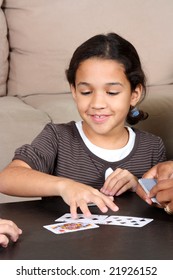 Family Playing Cards Together Around The Table