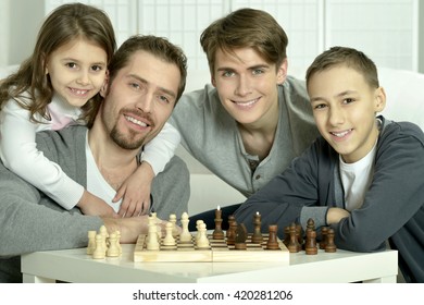 Family Playing Chess At Home