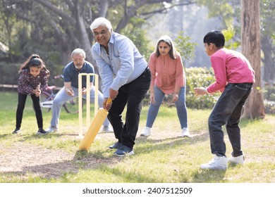 Family playing cricket in park - Powered by Shutterstock