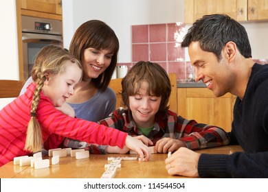 Family Playing Dominoes In Kitchen