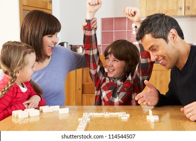 Family Playing Dominoes In Kitchen