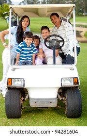 Family Playing Golf And Riding A Cart Though The Course