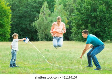 Family Playing With Jump Rope In The Park