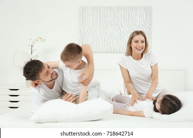 Family Playing On Bed In Hotel Room