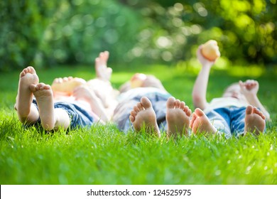 Family playing on green grass in spring park