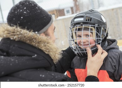 A Family Playing At The Skating Rink In Winter.