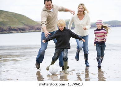 Family Playing Soccer At Beach Smiling