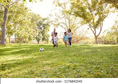 Family Playing Soccer In Park Together