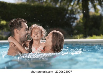 Family playing in swimming pool - Powered by Shutterstock