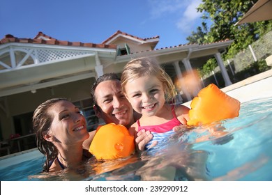 Family Playing In Swimming Pool Of Private Villa