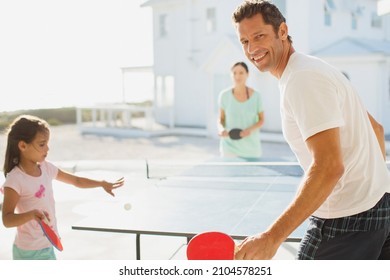 Family Playing Table Tennis Outside House