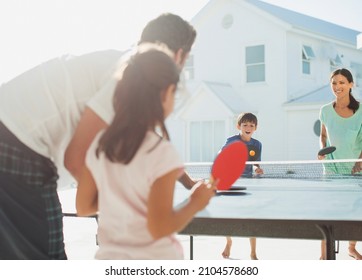 Family Playing Table Tennis Outside House