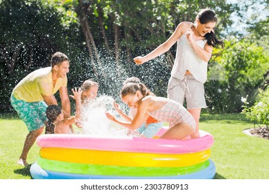 Family playing together in wading pool - Powered by Shutterstock