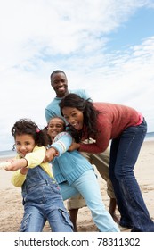 Family Playing Tug Of War On Beach