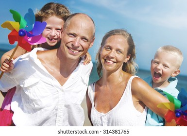 Family playing with windmill on beach Concept