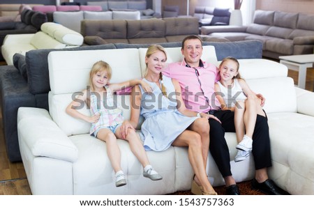 Family is pleased by new sofa in furniture store.