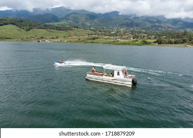 Family In Pontoon Boat And Jetski In Lake