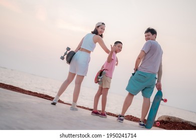 Family portrait, beach vacation, parents and children resting from skating, surfing, standing smiling happily. - Powered by Shutterstock