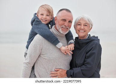 Family, Portrait And Child With Grandparents At A Beach, Hug, Relax And Smile While Having Fun On Vacation. Travel, Happy Family And Senior Couple Enjoy Ocean Trip And Quality Time With Grandchild