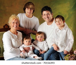 A family portrait composed of Mom, Dad and four sons -- a baby, preschooler, elementary boy and young teen.