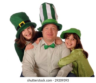 A Family Portrait Of A Dad And His Two Daughters Celebrating St. Patrick's Day Wearing Green And Weary Goofy, Over-sized Hats.  Isolated On White.