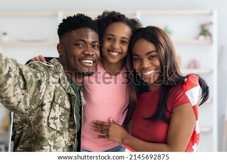 Family portrait of happy black kid, military husband and wife enjoying reunion, african american daughter and mother cuddling with father returned from army, taking selfie with flag of the US