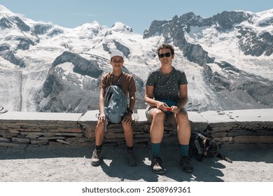 Family portrait, mother, daughter and their little black dog sitting near a snowy mountain in the Swiss Alps - Powered by Shutterstock